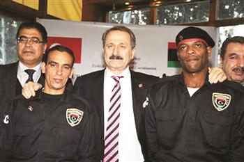 Turkish economy minister Zafer Caglayan with Libyan policemen in uniforms donated by Turkey.