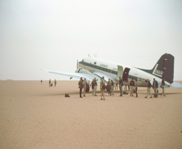Figure 4: PESL participants in one of the field excursions in the Libyan Sahara in the 1960s. The Linair plane was an airliner used in Libya at the time (a DC-3)  which could land without a proper airstrip (here on a flat gravel plain 'serir' surface).