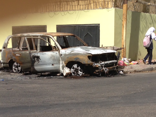A burned-out vehicle outside the embassy belonging to embassy staff. 