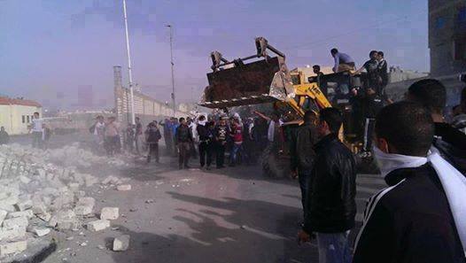 Protestors take a bulldozer the the SSC wall