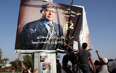Protestors tear down poster, accusing him of being with the Muslim Brotherhood (Photo: Fadlullah Bujwary)