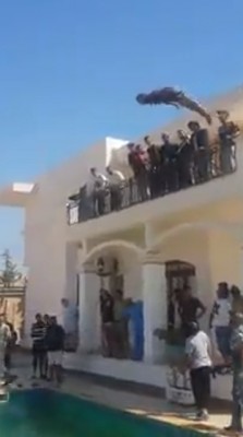 A militiaman dives from a balcony into the US embassy compound pool (Photo: social media)