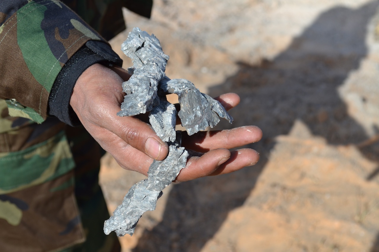 A security guard at Mitiga shows shrapnel from today's bomb attack (Photo: Libya Herald)
