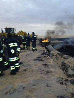 Firemen in final stages of extinguishing the first blaze