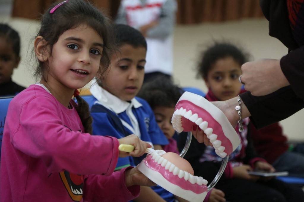 giving an outsize demonstration of the big matter of cleaning teeth properly (photo: Libya Red Crescent)