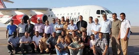 Passengers pose for a group photo after the first flight back to Nafoura 