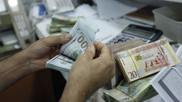 A man counts U.S. dollars at a currency exchange office in central Tripoli