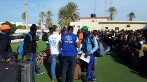 IOM staff helping Burkina Faso migrants at Tripoli's Mitiga airport on their way back home (IOM).