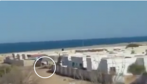 LNA forces (a technical is circled) enter Ras Lanuf (video grab)