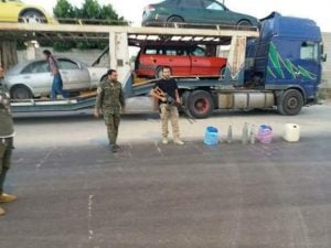 Militiamen display explosives found aboard the transporter. (Photo: social media)